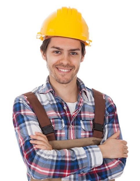 Man wearing a yellow construction helmet, plaid shirt, and work overalls, standing with arms crossed and smiling at the camera against a white background.